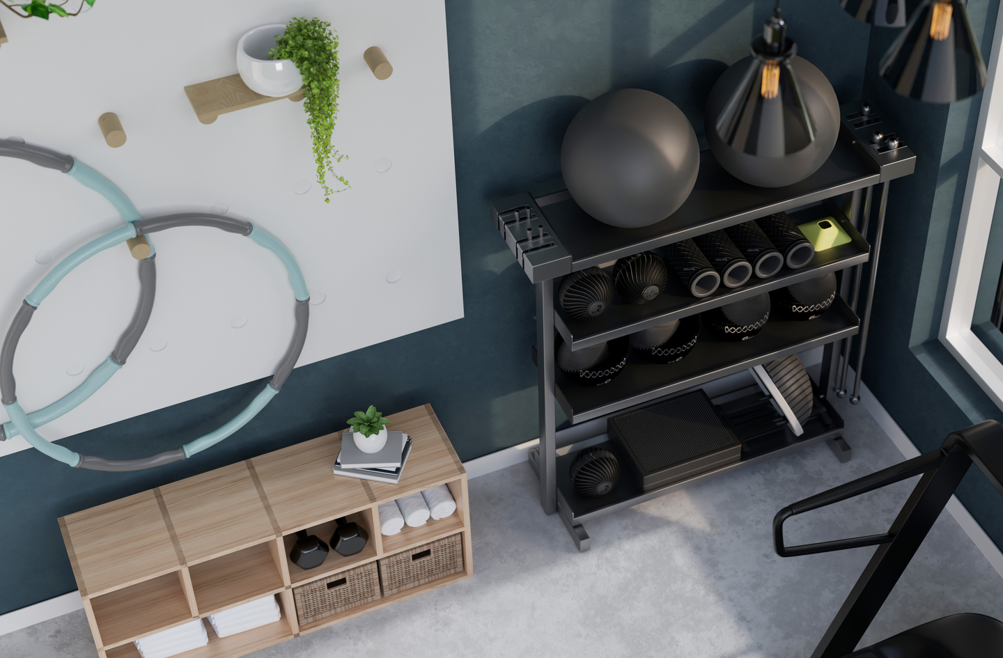 Small home gym storage ideas seen from above: an open shelf rack of medicine balls and foam rollers, a low wooden cube shelf and a wall pegboard holding hoops.